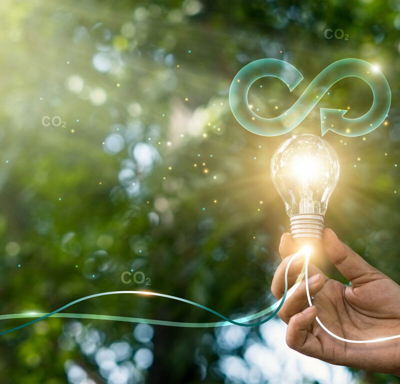 Circular economy. Hand hold light bulb with circular icon. Energy consumption and CO2 emissions, reusing and recycling existing materials for future growth of business and environment sustainable.
